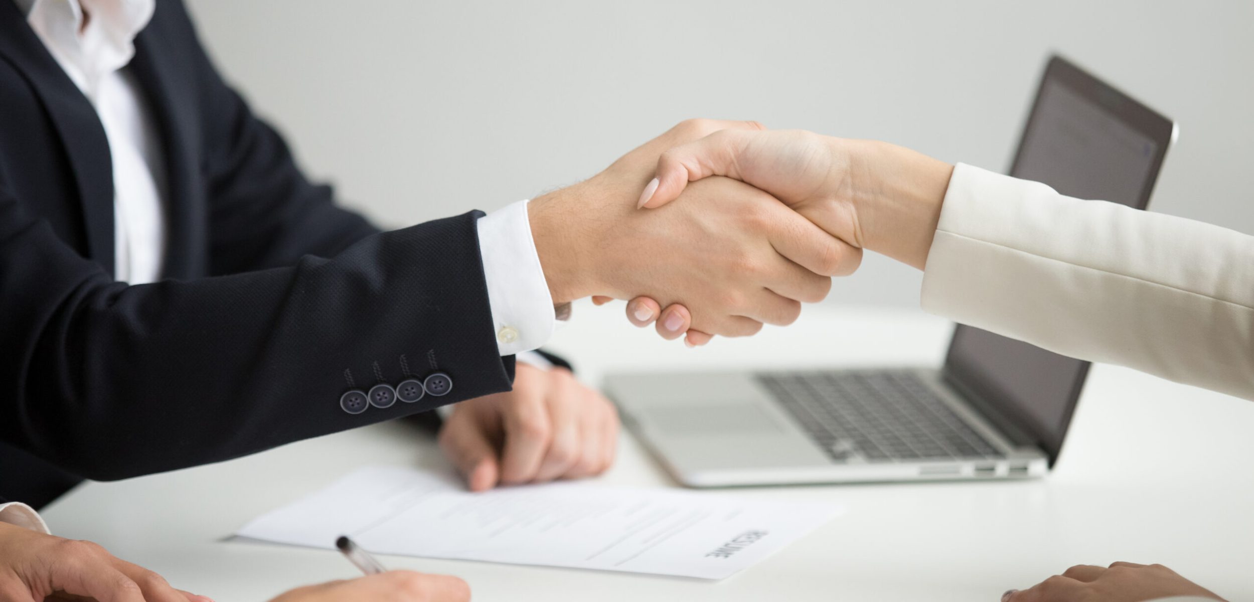 Employment handshake concept, female hr and successful woman candidate shaking hands getting hired ready to sign job contract concept, employer congratulating welcoming new worker, close up view